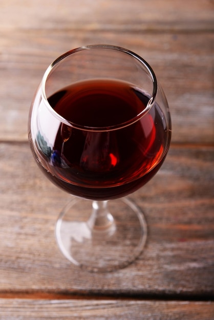 Стакан красного вина на деревянном столе