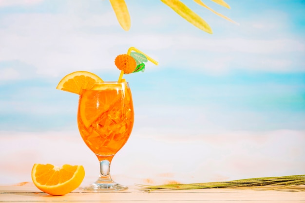 Стакан освежающего сочного напитка и нарезанный апельсин