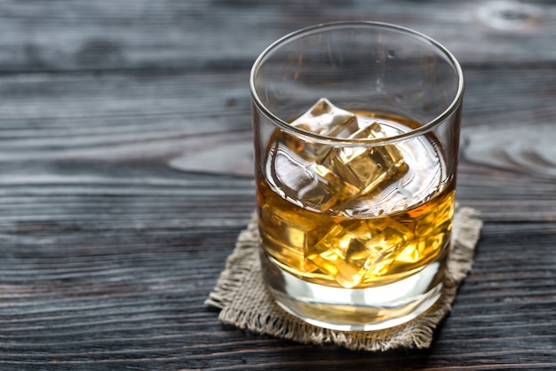 Glass of rum on the wooden background