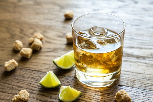 Glass of rum on the wooden background