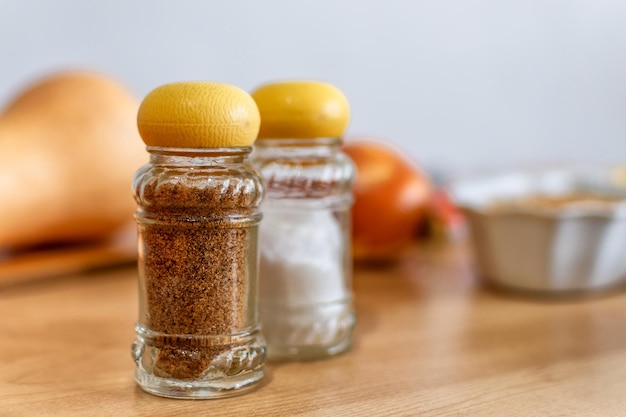 Glass salt and pepper shakers on wooden board