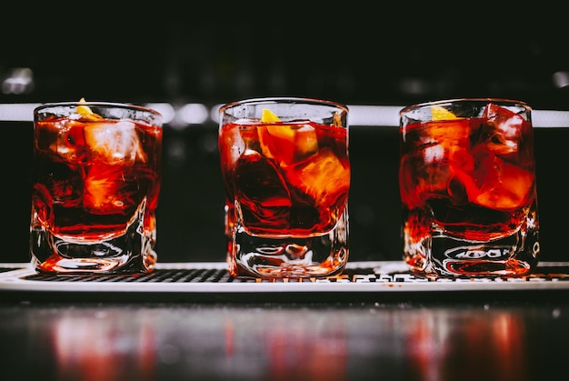 Glass of scotch whiskey and ice on the background of the bar vintage photo processing