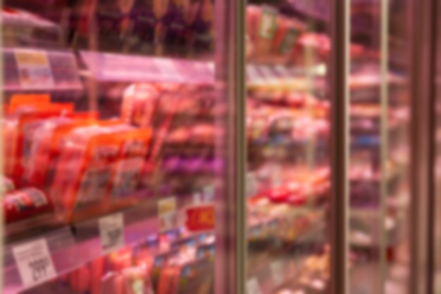 Glass showcase with chilled meat products in the store.
blurred. side view.