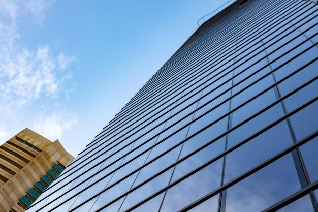 Glass skyscraper against blue sky view from bottom