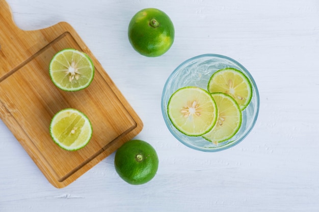 A glass of soda, lemon and lime on the table