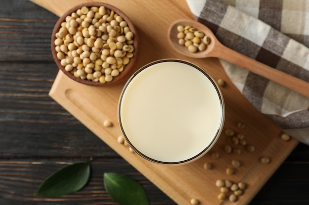 Photo glass of soy milk and soybeans seeds on wooden