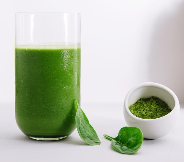 Glass of spinach detox juice isolated on white