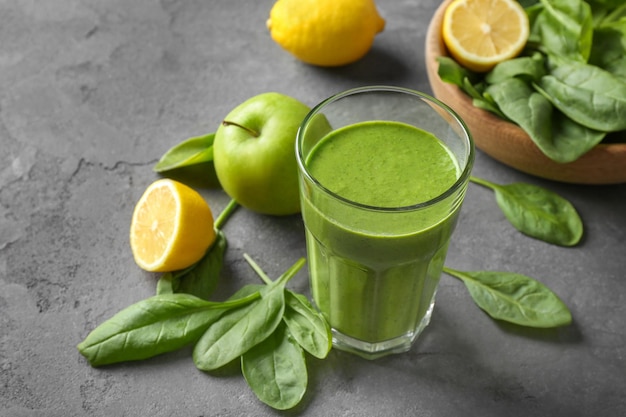 Glass of spinach smoothie on table