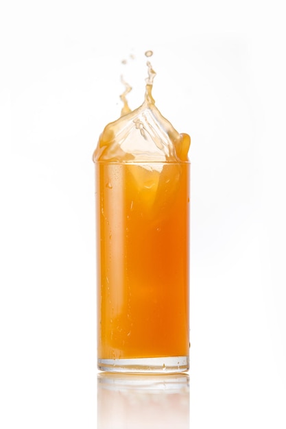 The glass of splashing fruit juice isolated on white background