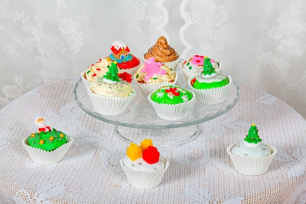 A glass stand with homemade cakes cupcakes muffins decorated in a Christmas style