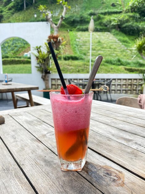 Photo glass of strawberry juice on the table