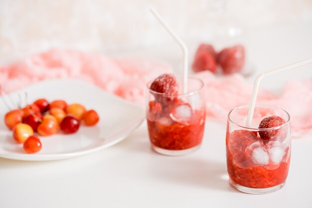 A glass of strawberry smoothie on a wooden background