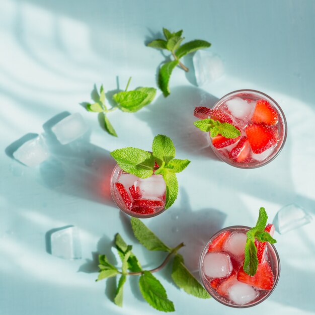 Bicchiere di bibita alla fragola su azzurro. limonata disintossicante estiva, cocktail o un'altra bevanda