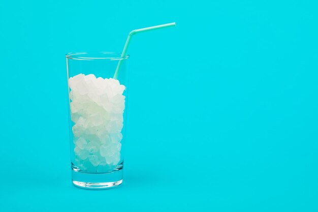 Glass of sugar. The concept of junk food. On red background.