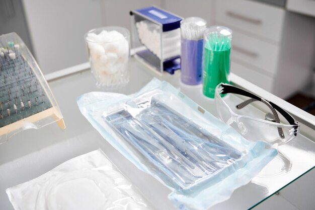 Photo glass table in dentist office with all necessary tools for teeth treatment