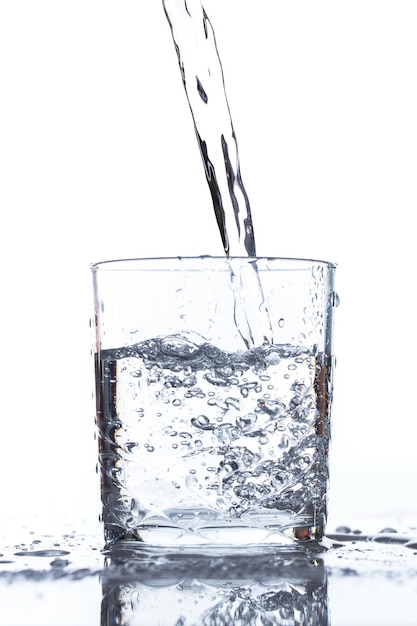 Glass on the table pouring pure water