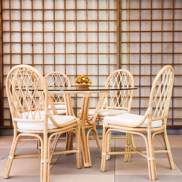 Glass table with wickler chairs in an elegant interior