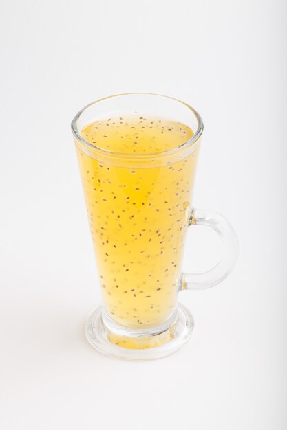 Glass of tangerine orange colored drink with basil seeds isolated on white background 