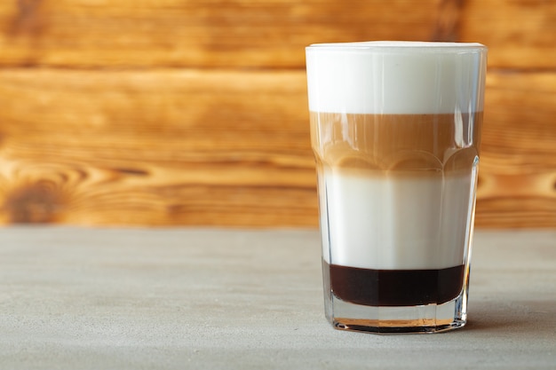 Foto bicchiere di gustoso latte aromatico su fondo in legno