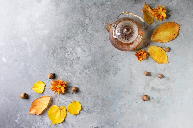 Glass teapot with autumn leaves