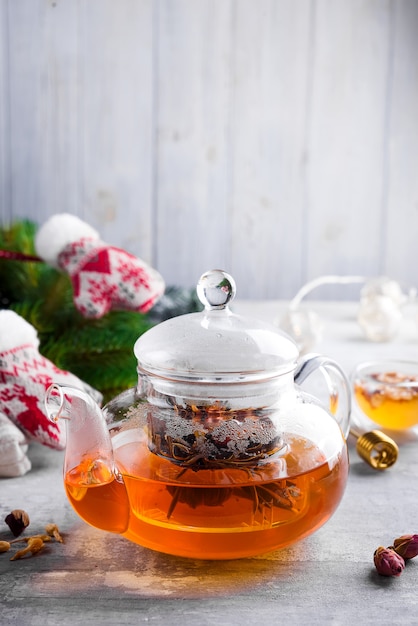 Photo glass teapot with flowers tied tea, hot tea in glass teapot and honey