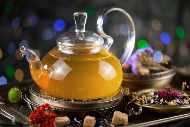 A glass teapot with a glass container filled with tea.