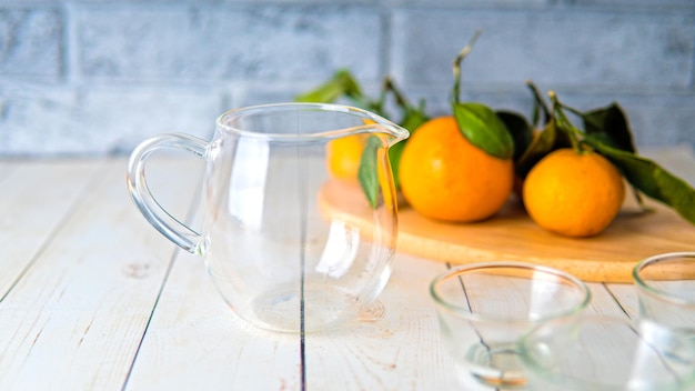 A glass teapot with the small cups on the table