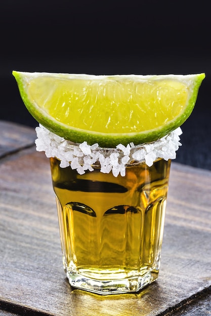 Glass of tequila black background typical mexican drink