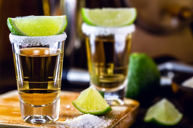 Bicchiere di tequila, bevanda della cultura messicana, a base di alcol distillato, limone, sale e agave blu. giornata internazionale della tequila.