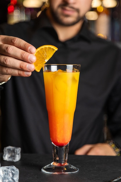 A glass of tequila sunrise cocktail and red tequila sunrise\
with a cherry tequila sunrise