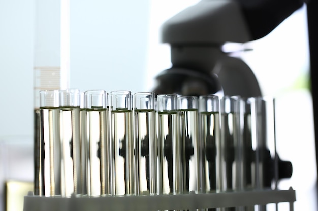 Glass test tubes with yellow liquid on of microscope