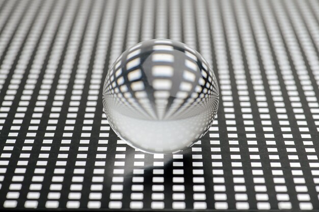 Photo glass toy sphere on a square holed black lattice