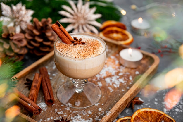 A glass of traditional christmas drink eggnog on a festive table spicy drink made from egg and milk