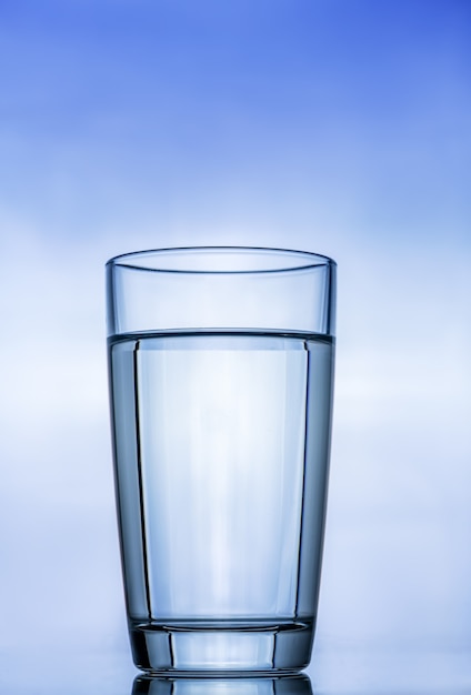 Фото Стекло прозрачное стекло с чистой водой против голубого неба. с отражением