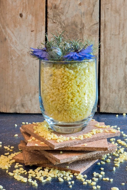 黄色い石とニゲラ・ダマセナの花で満たされたガラスの花瓶