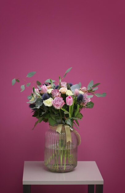 Glass vase with beautiful bouquet on color background