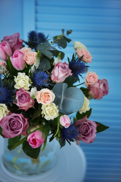 Glass vase with beautiful bouquet on color background