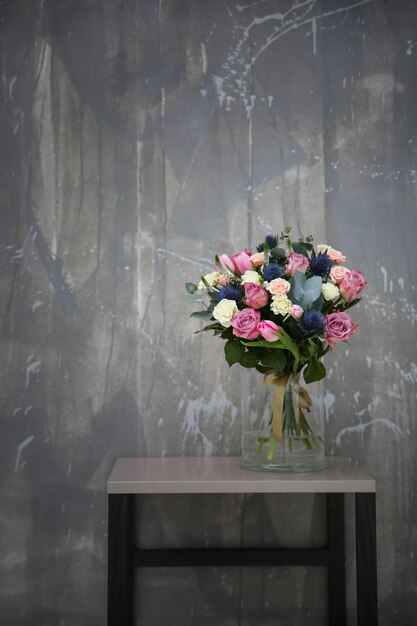 Glass vase with beautiful bouquet on color background