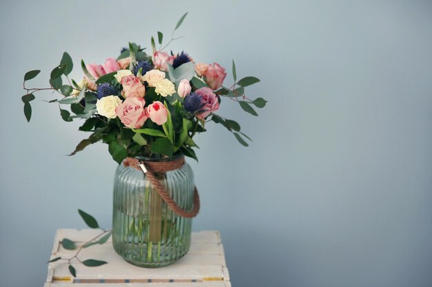 Glass vase with beautiful bouquet on color background