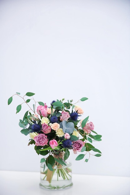 밝은 배경에 아름다운 꽃다발이 있는 유리 꽃병