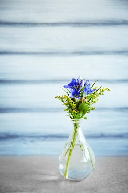 Premium Photo | Glass vase with bouquet of beautiful flowers on color