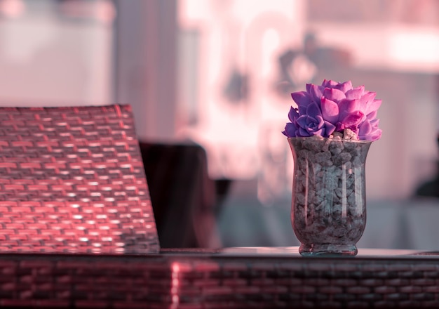 机の上に美しい紫色の花の花束とガラスの花瓶
