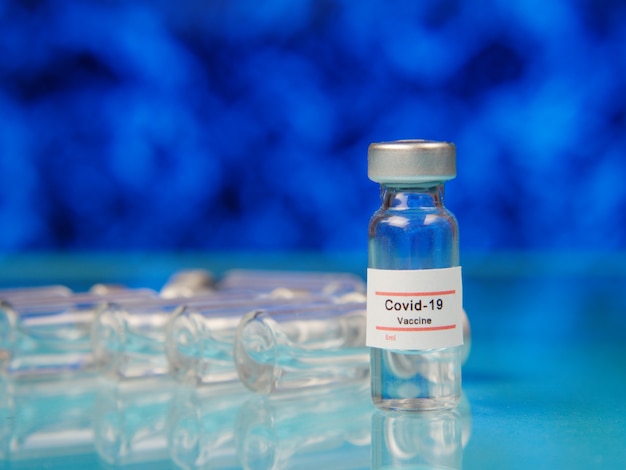 glass vial of covid vaccine on the table