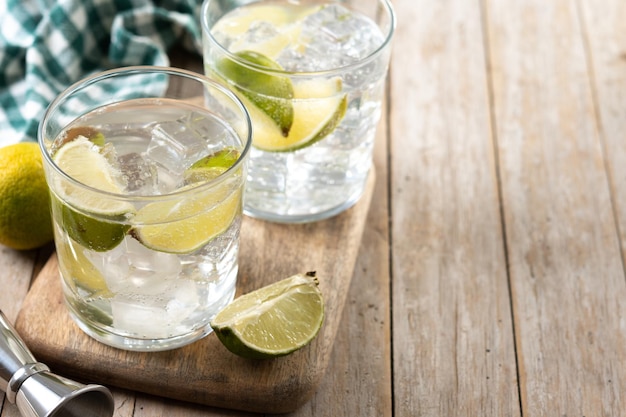 Glass of vodka tonic cocktail on wooden table Copy space