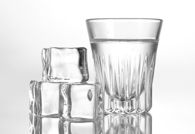 Glass of vodka with ice isolaled on white