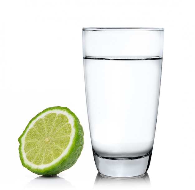 Glass of water and bergamot fruit on a white surface