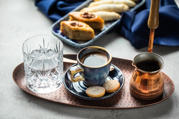 Glass of water and black coffee cup barista making drip coffee\
by pouring spills hot water