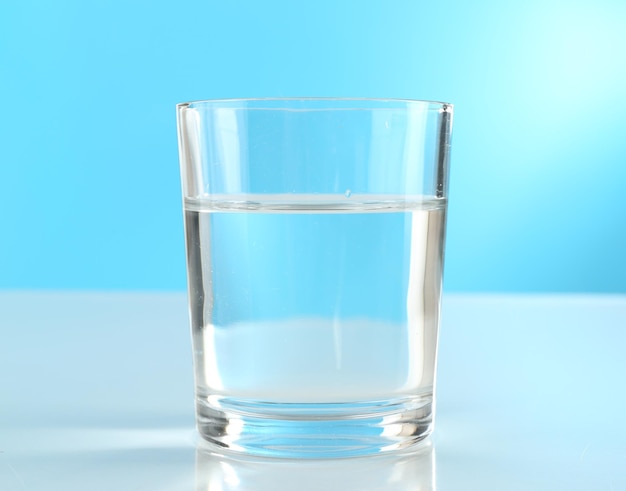 Glass of water on blue background