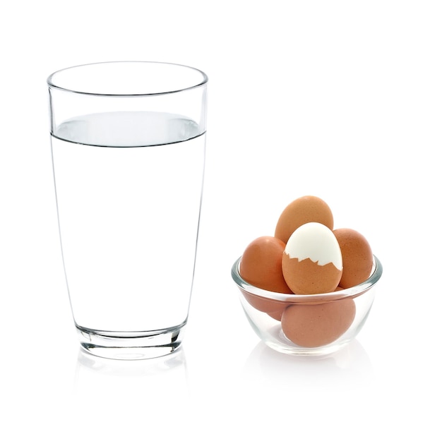 Glass of water and boiled egg isolated on white