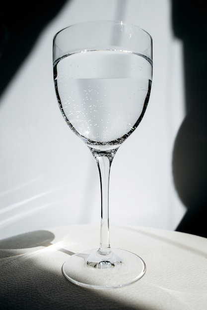 Foto bicchiere d'acqua. un bicchiere riflette il bagliore. vetro trasparente con vino.